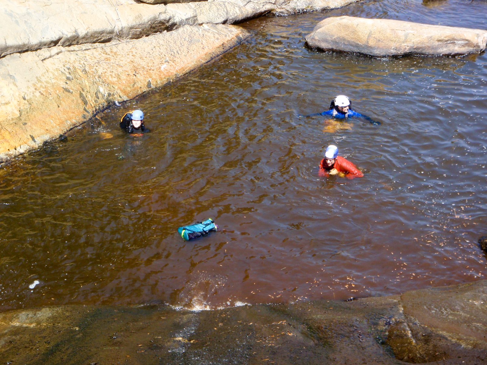 Monica, Catherine and Joel swim in the muddy brown water.