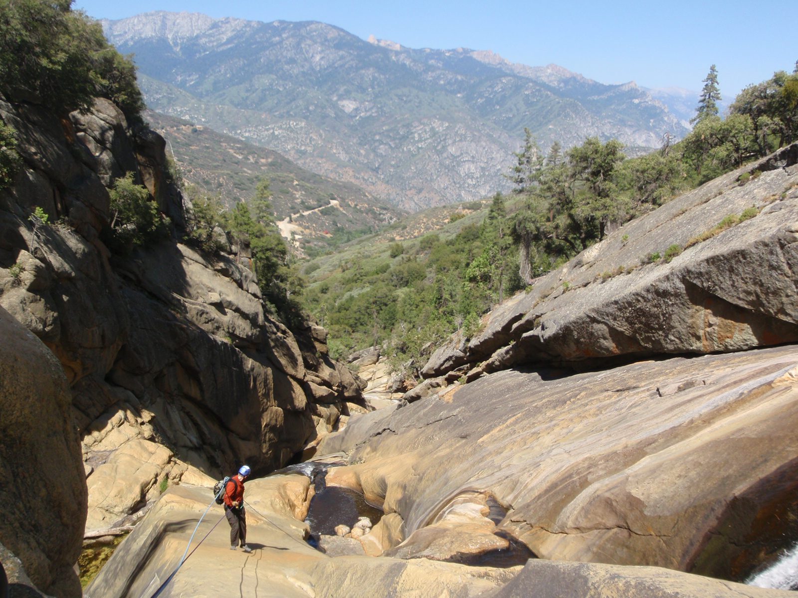Joel on the second rappel.  The road in the background is our destination and despite how close...