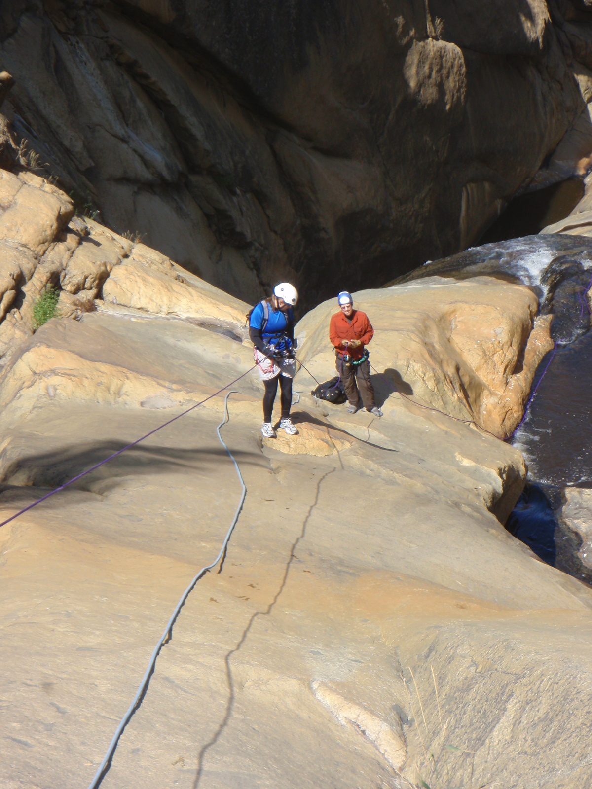 Catherine on the second rappel, while Joel provides a fireman's belay.