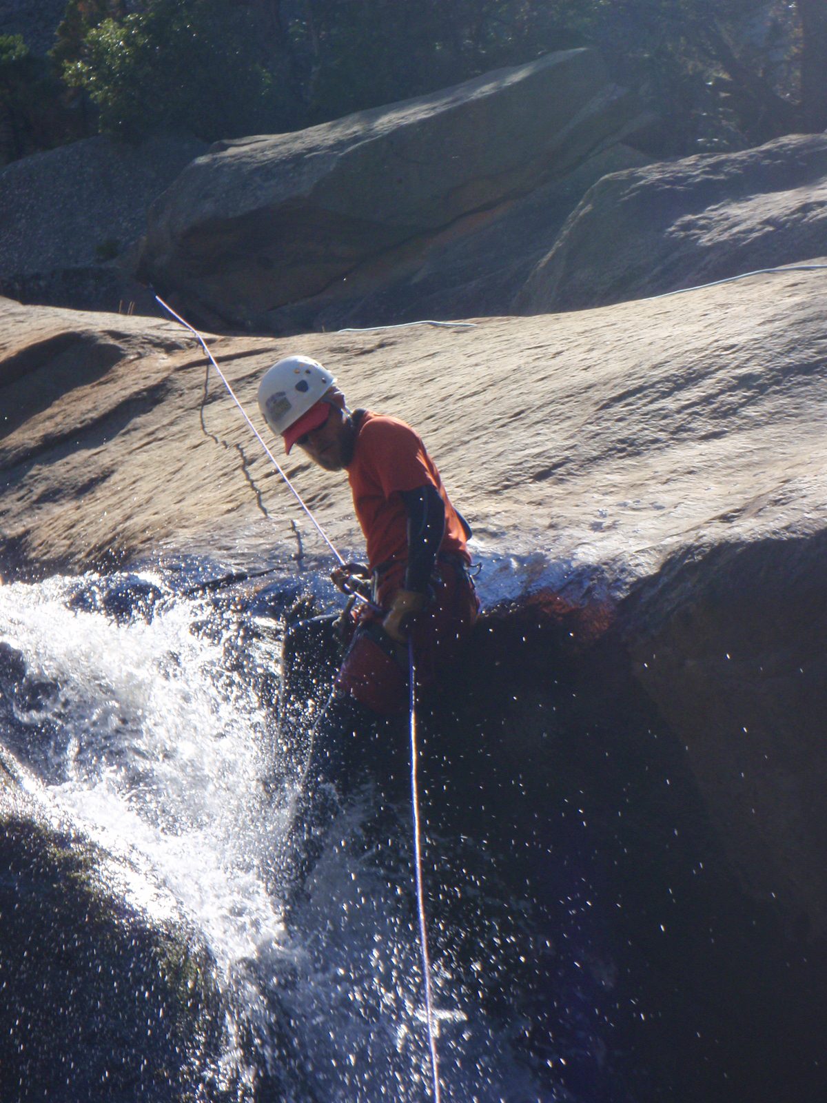 John lowering himself into a waterfall.