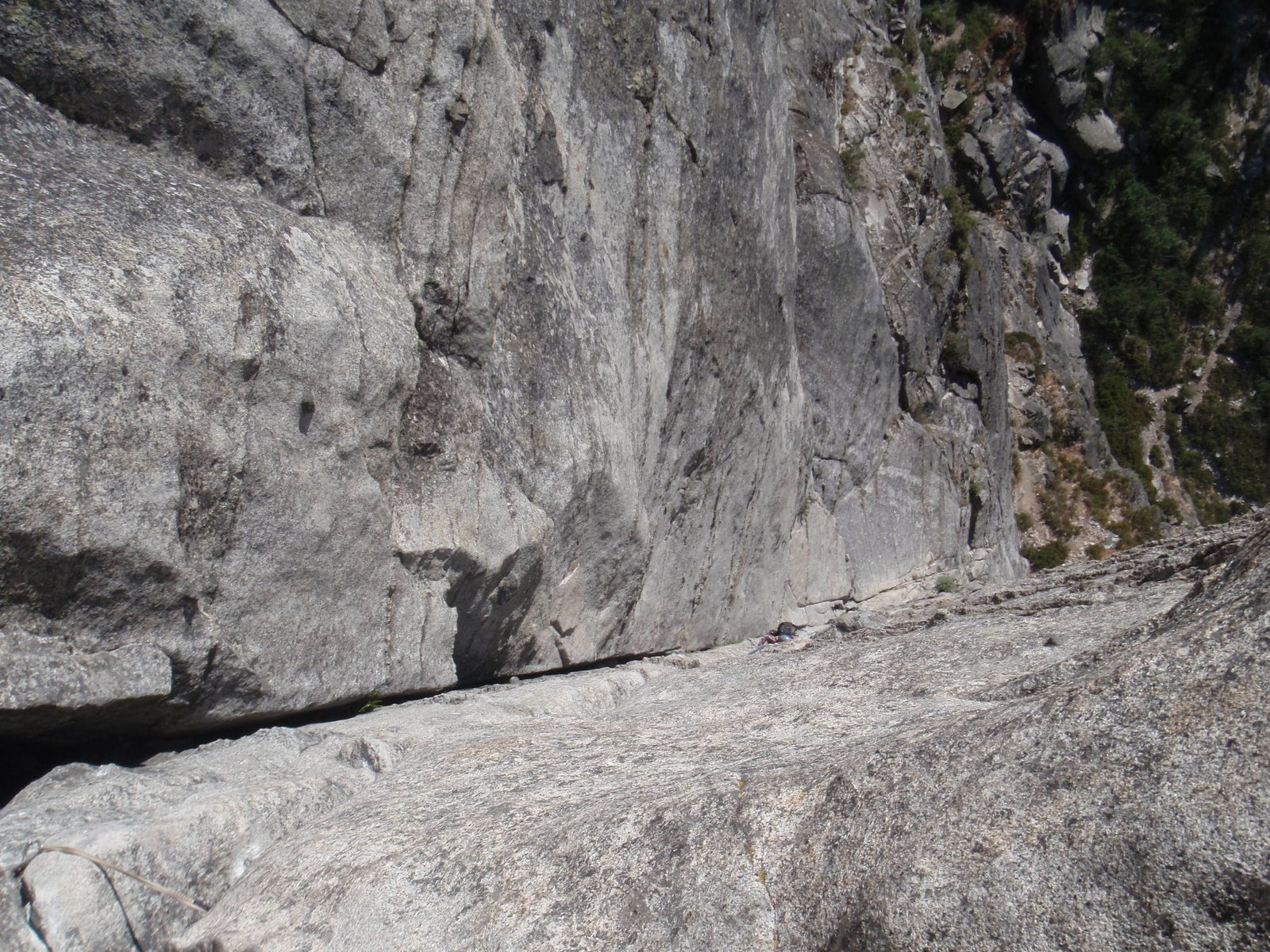 Spot the green backpack and blue helmet, moving up the wall.