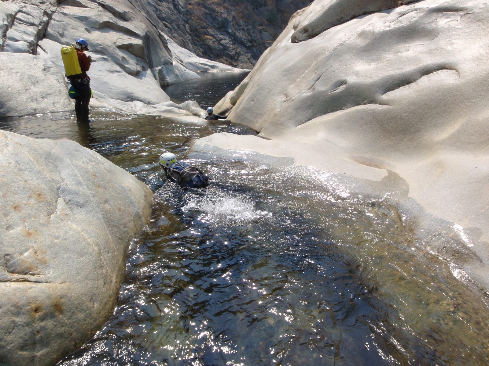 Floating down the river.  Joel looks on as Andy (foreground) and Mike (background) float down a...