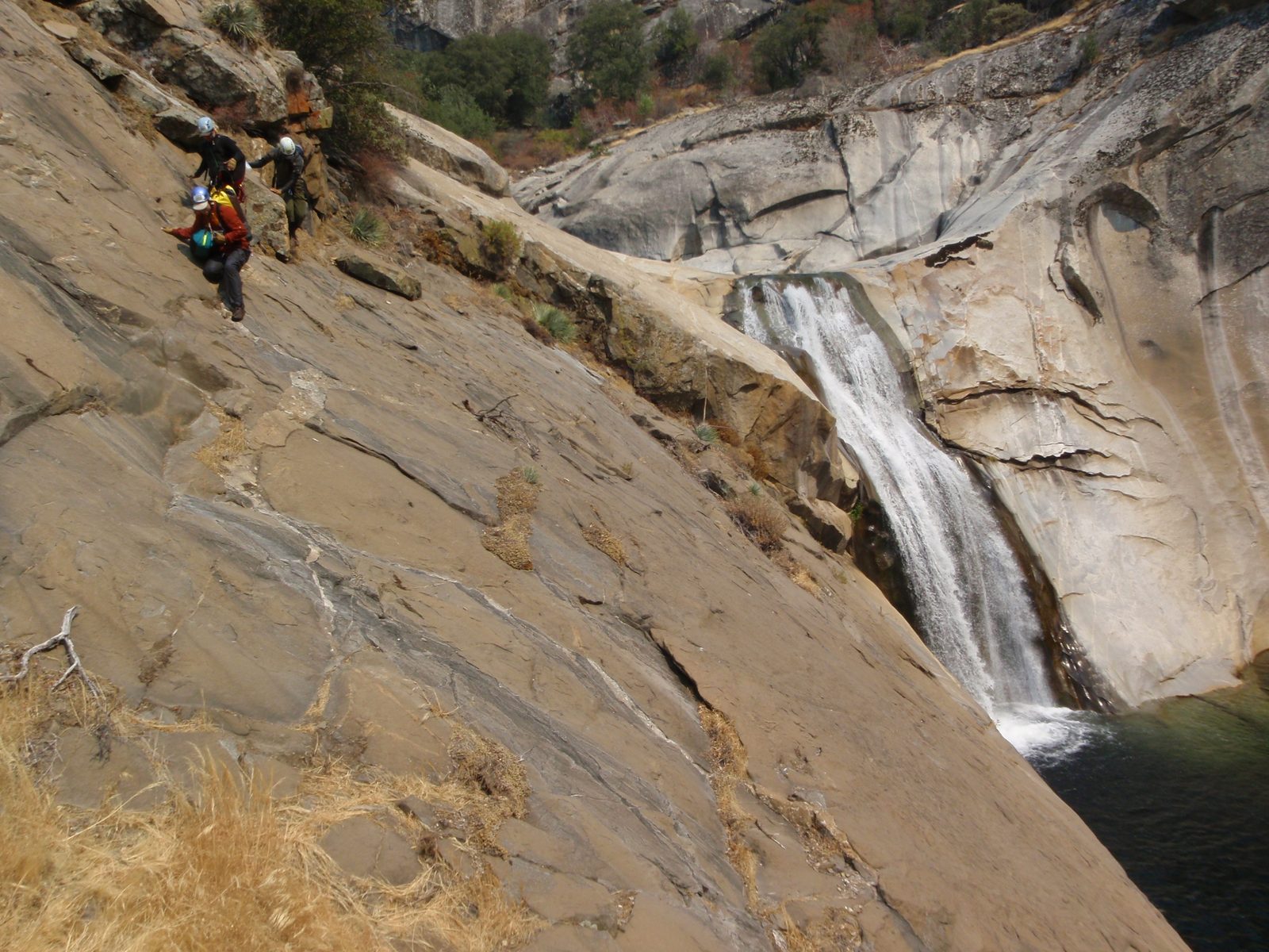 Joel, Mike, Andy carefully working across a steep traverse to avoid the 70 foot waterfall in the...