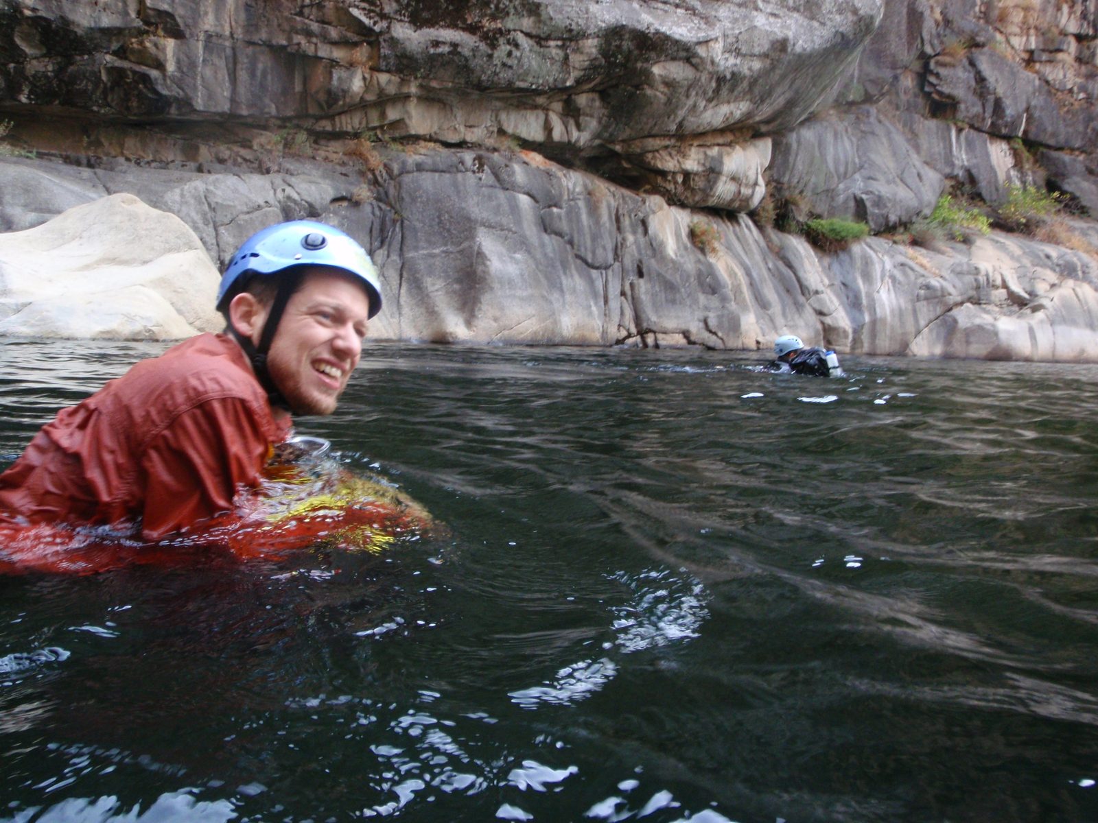 Joel, floating down river, using his bag as a flotation aid.