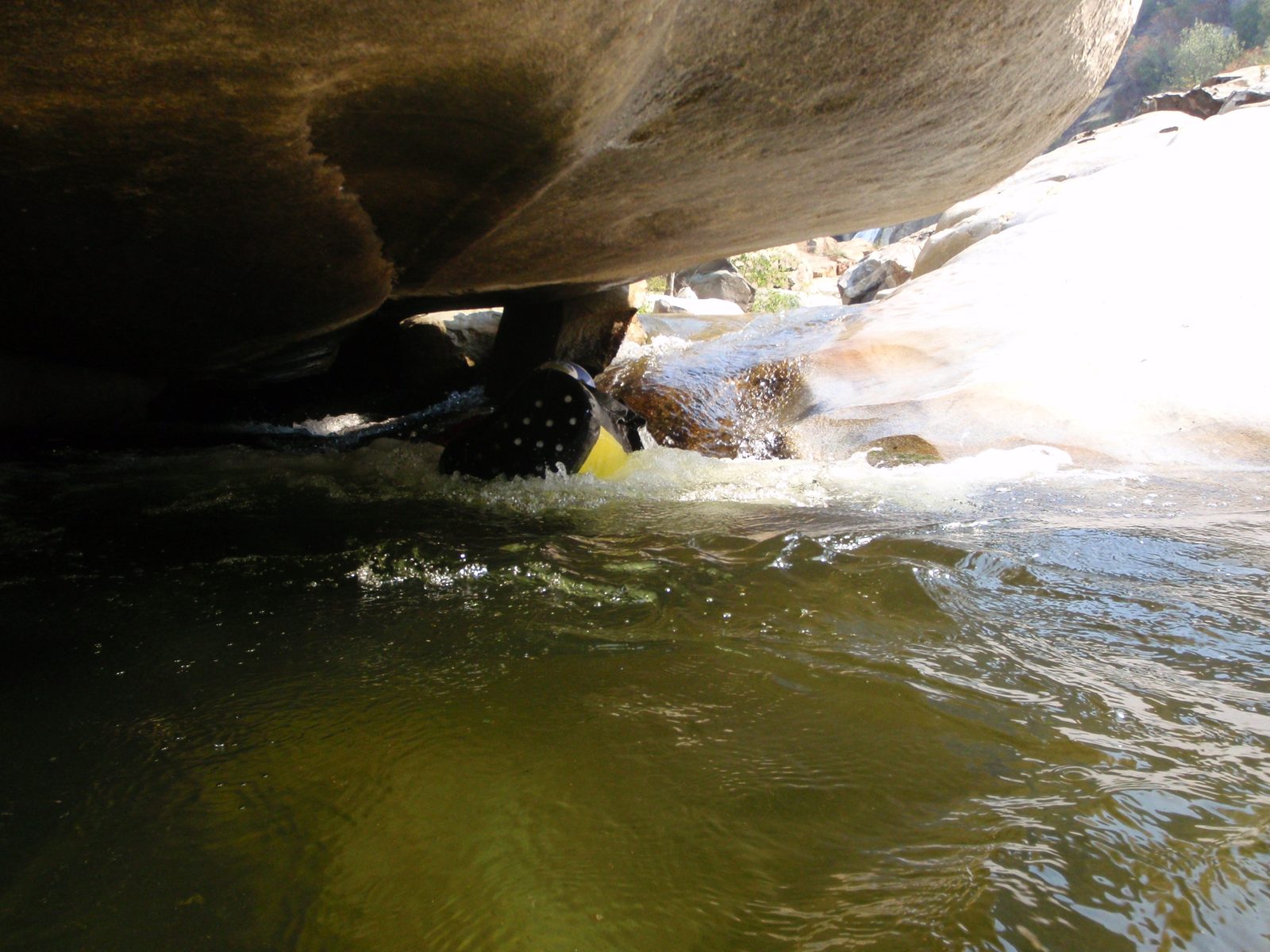 Joel, passing under a large boulder in the river.