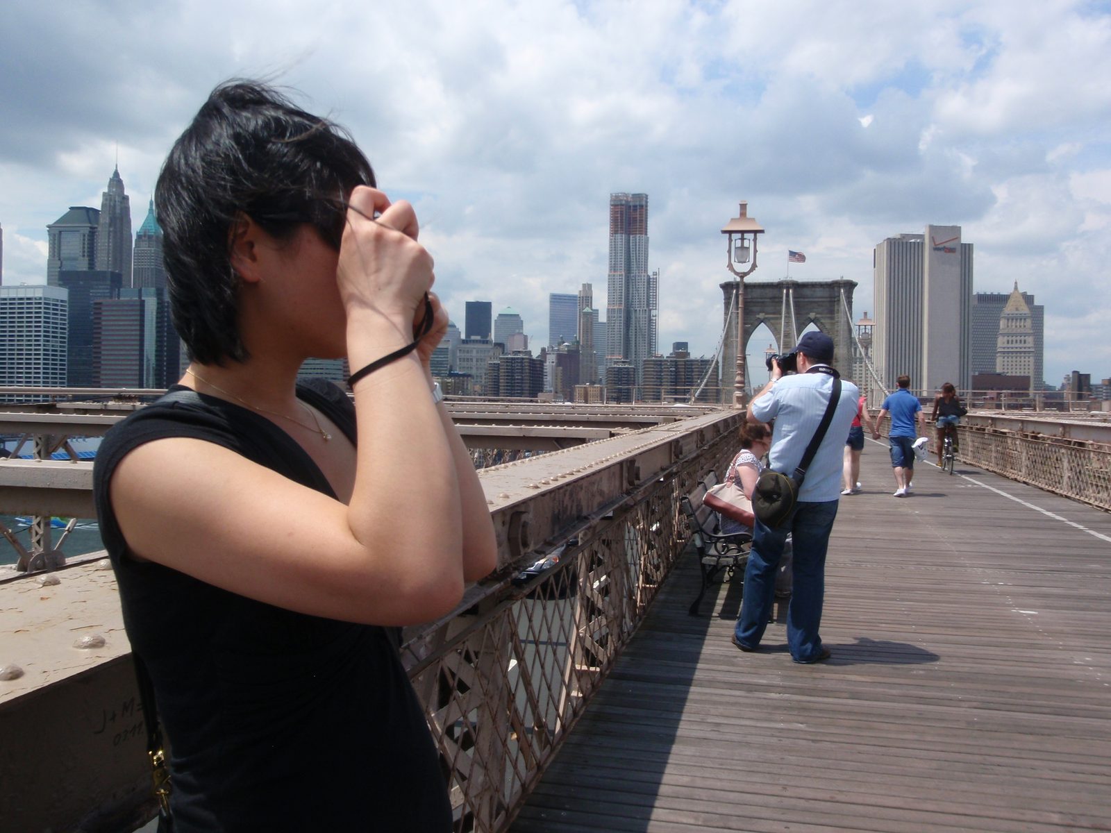Monica snapping a photo on the Brooklyn Bridge.