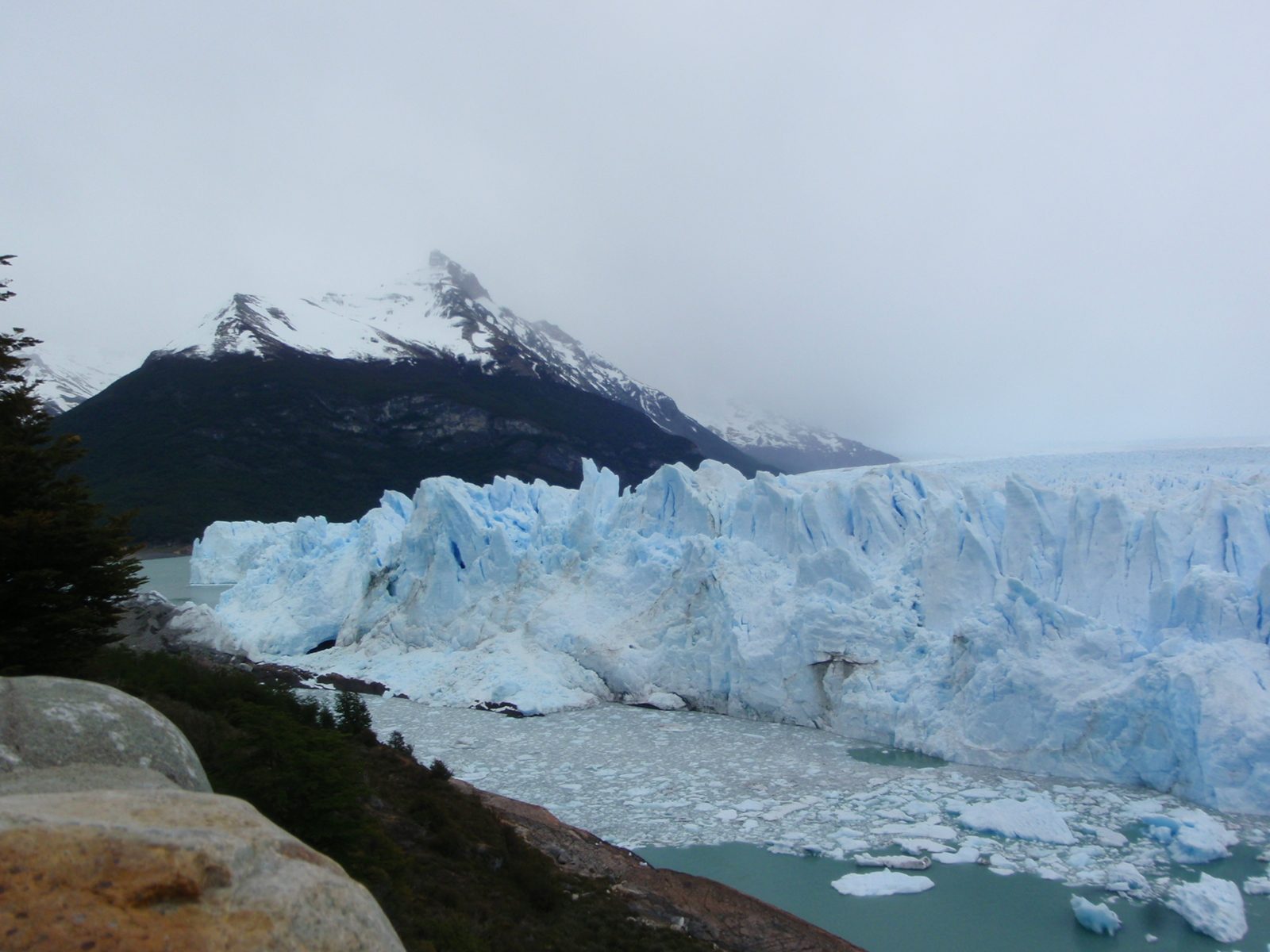 That semi-circular patch of water without any icebergs is where a bunch of ice just fell off...