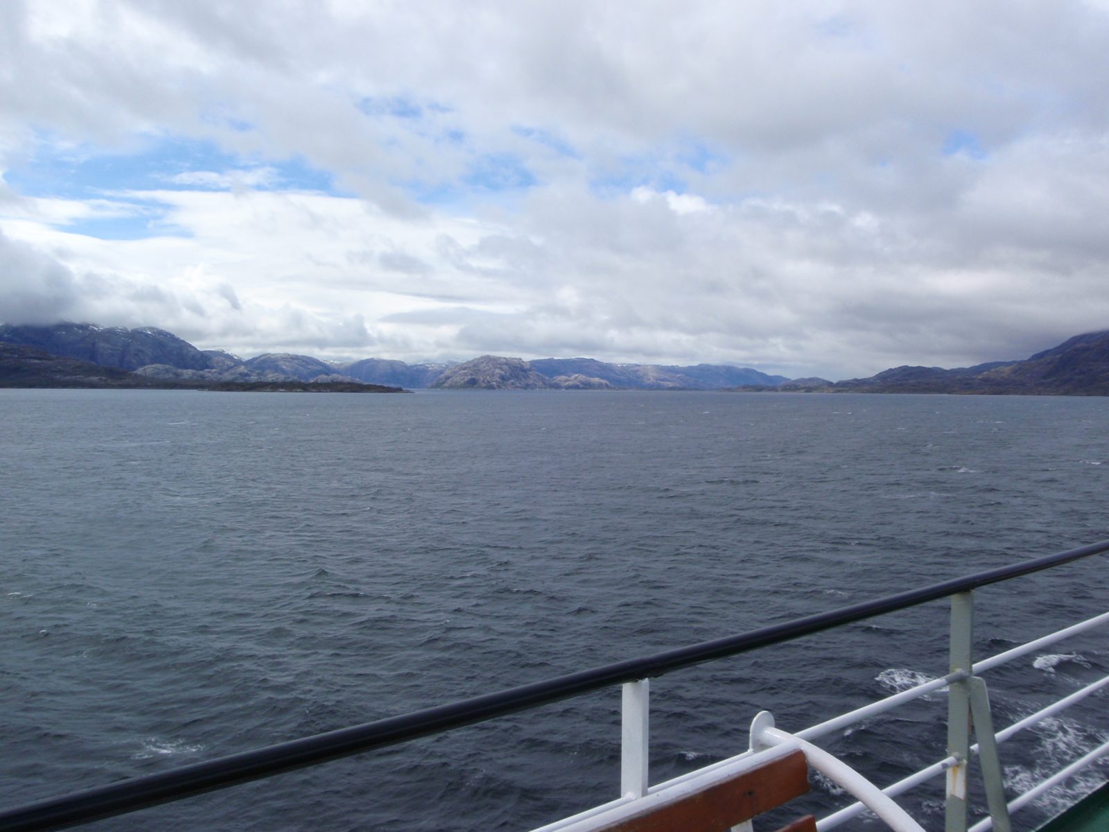More beautiful azure waters and green mountains capped in snow and clouds.
