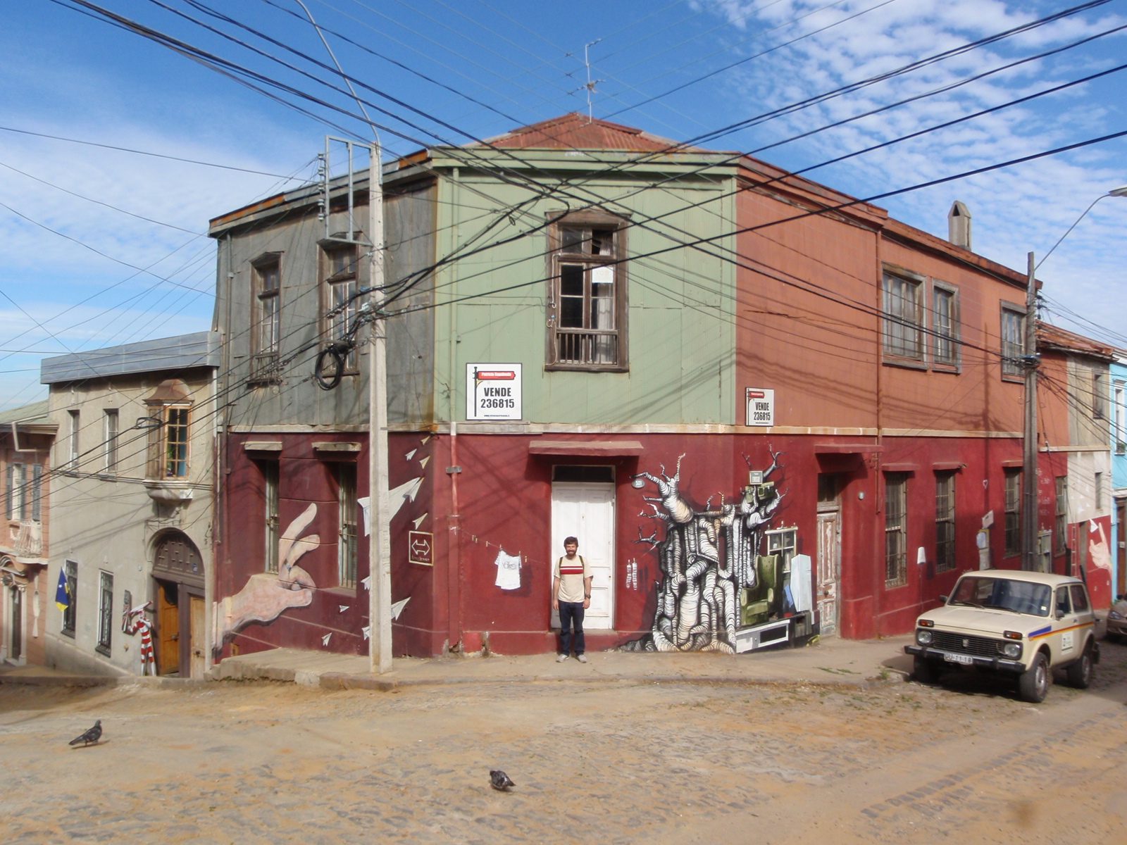 Jay has his photo taken in front of a building with some interesting murals. 