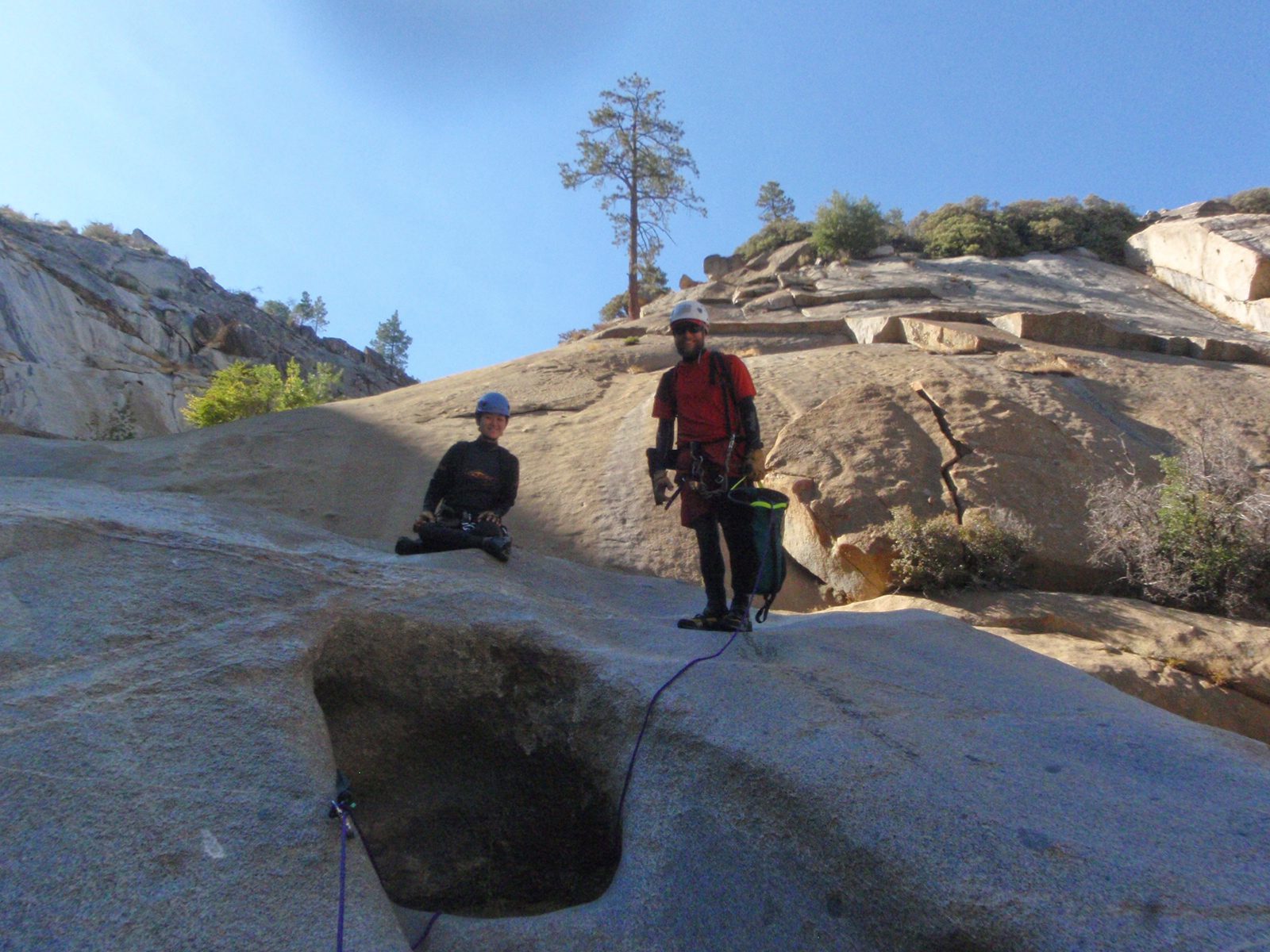 Catherine, on rappel, snaps a shot of John and Monica at the top of rappel #5.