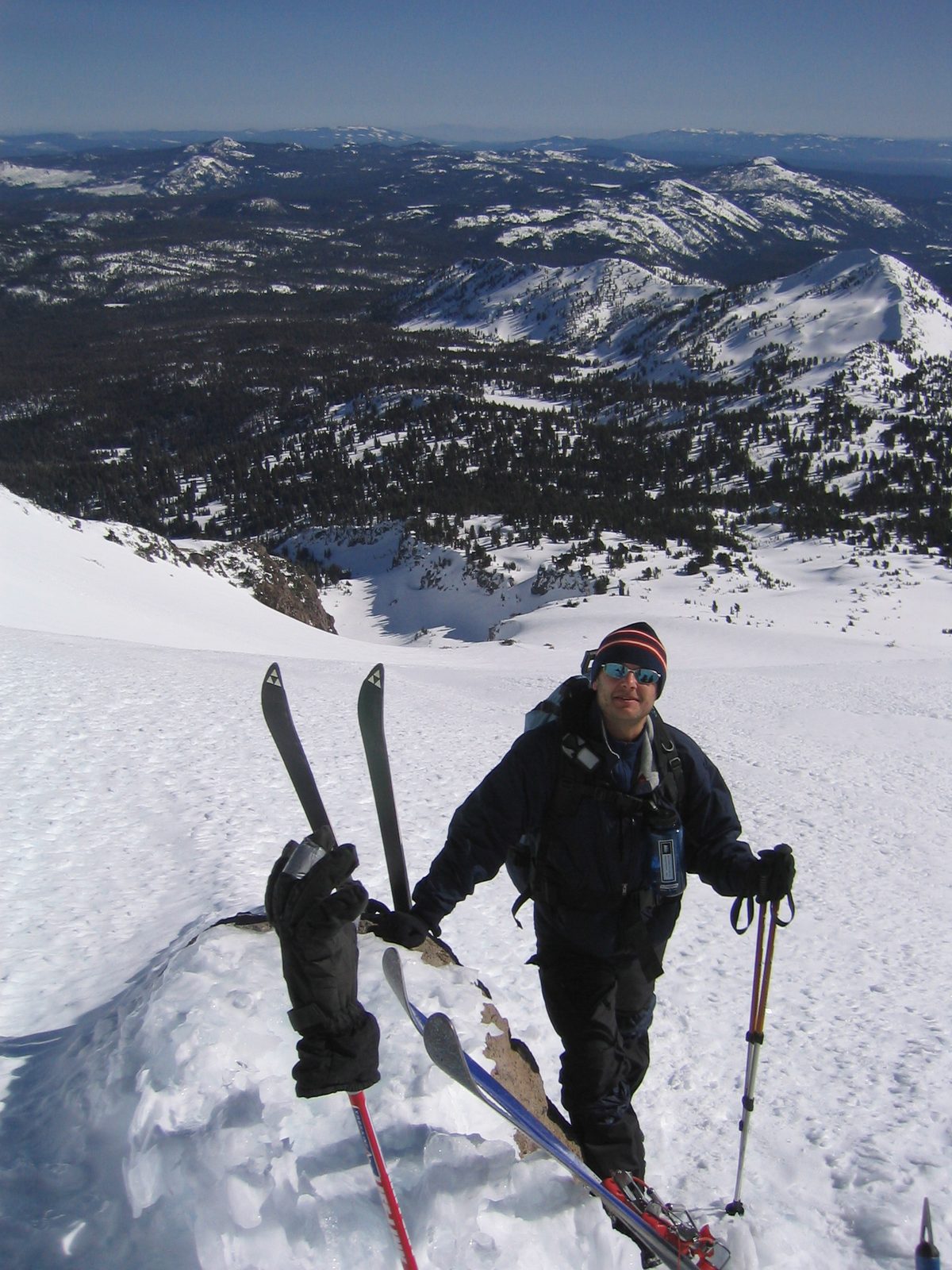 Niels, having reached the highest point of our ascent (approx. 9700 ft), readies his skis for...