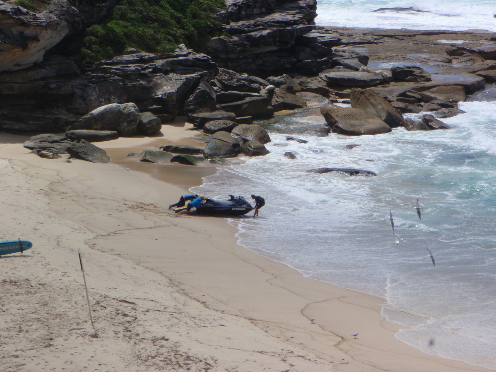 Lifeguards trying to launch a jet ski.