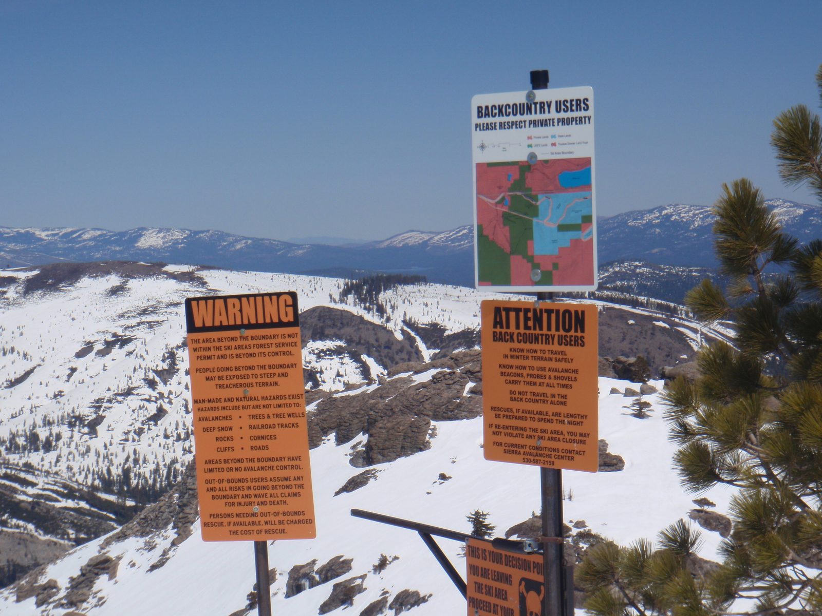 Signs at the border of Sugar Bowl ski area. Donner Lake is just barely visible at the center of...