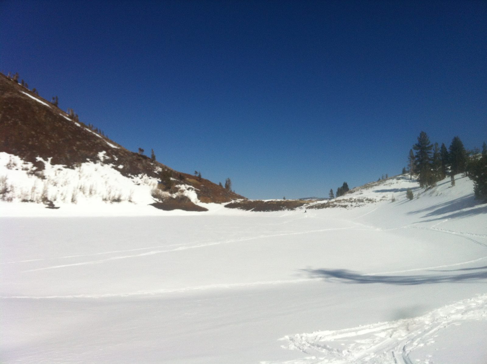 There seems to be a mad made earthen dam at the end of this lake.