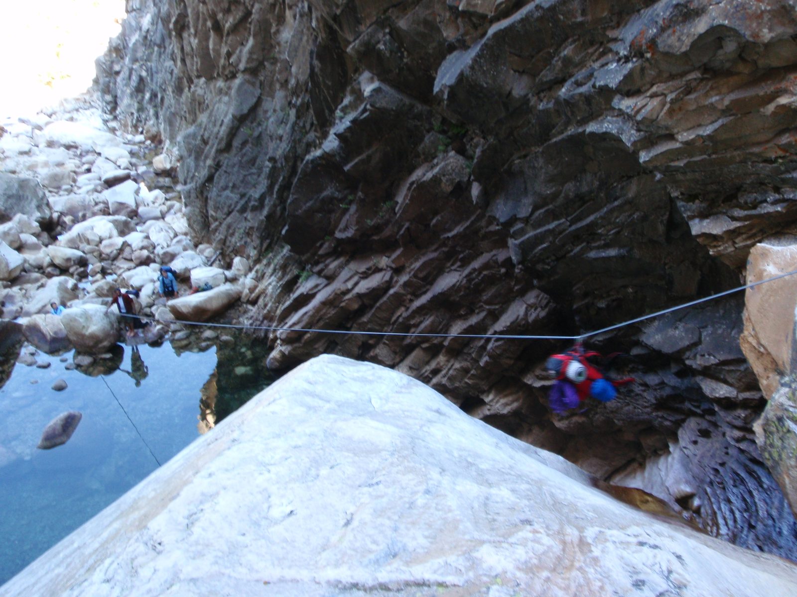We constructed a rudimentary zip line, anchored at the top to slings and at the bottom to a...
