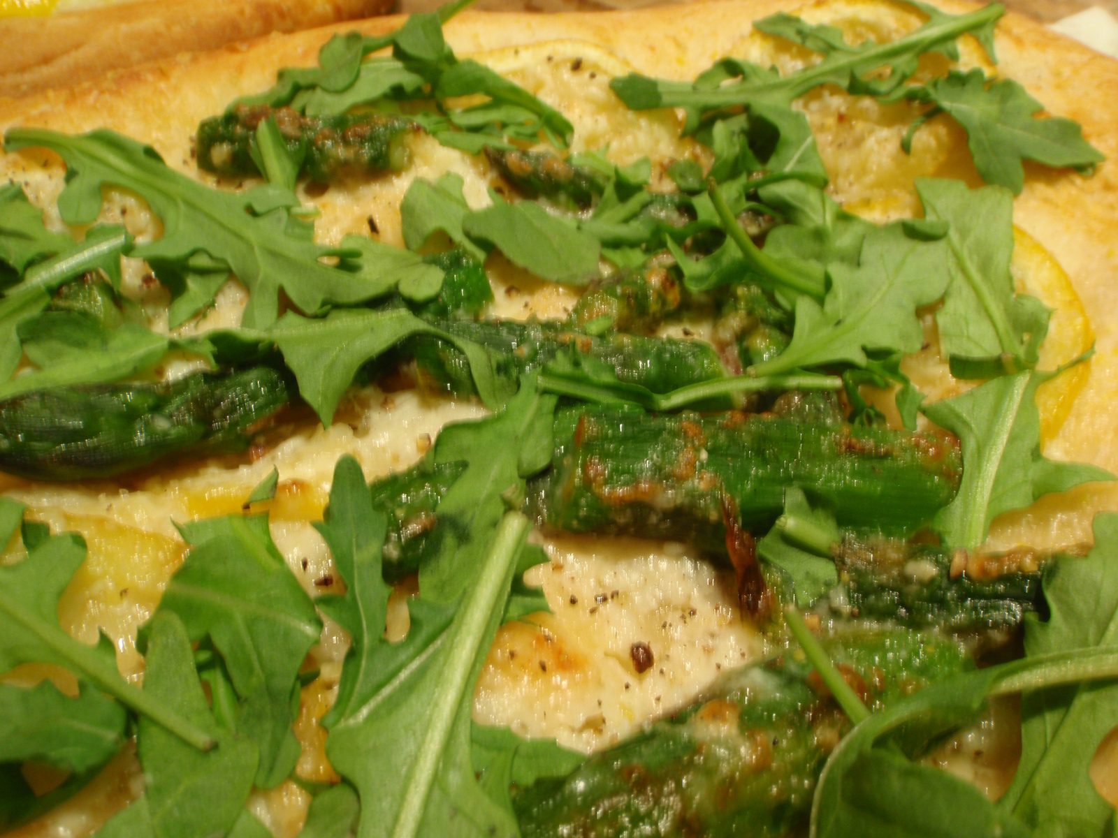 Detail of lemon, asparagus, arugula pizza.