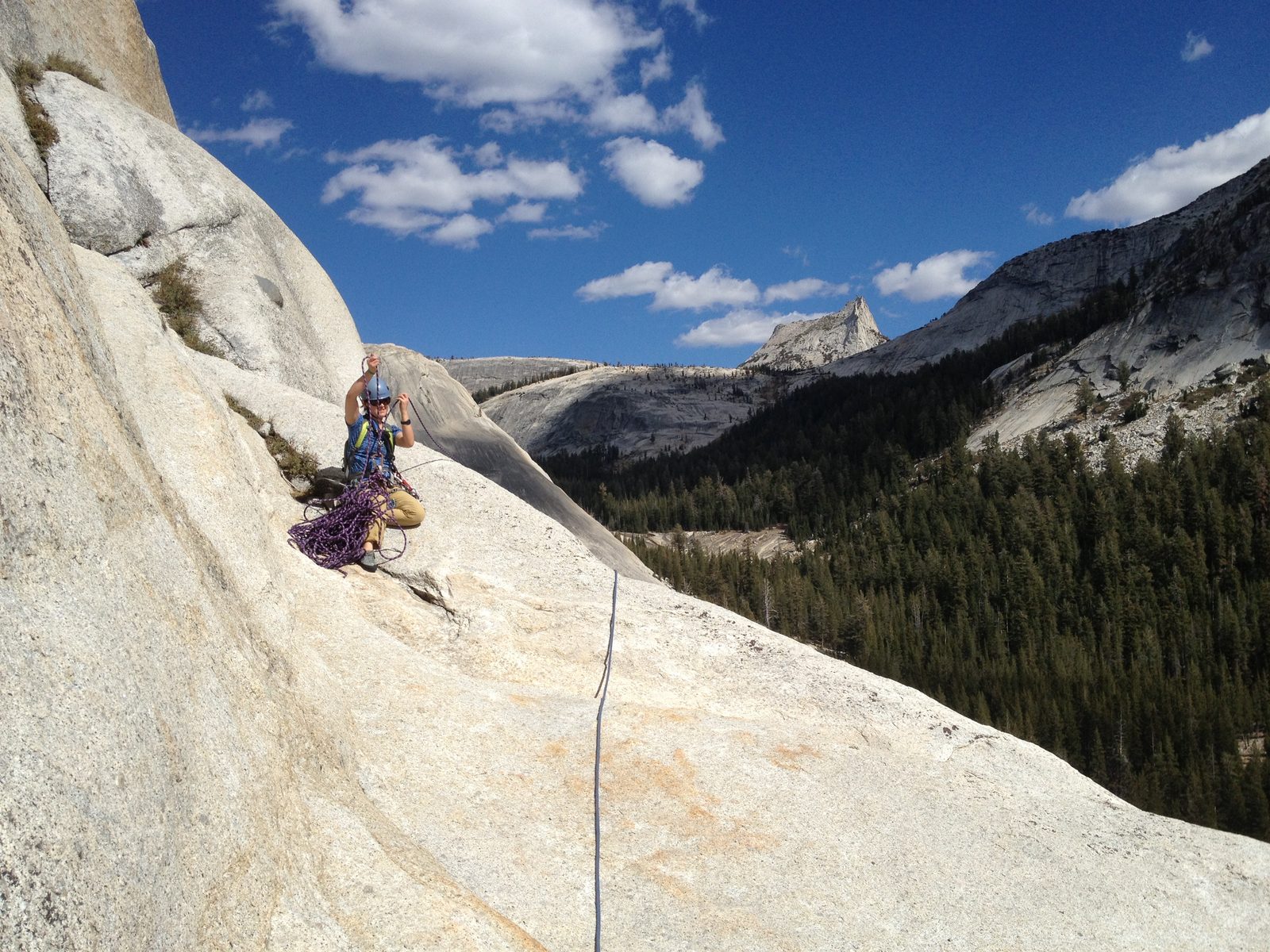 Monica, sorting some rope on the enormous first belay ledge. Cathedral Peak in the distance.