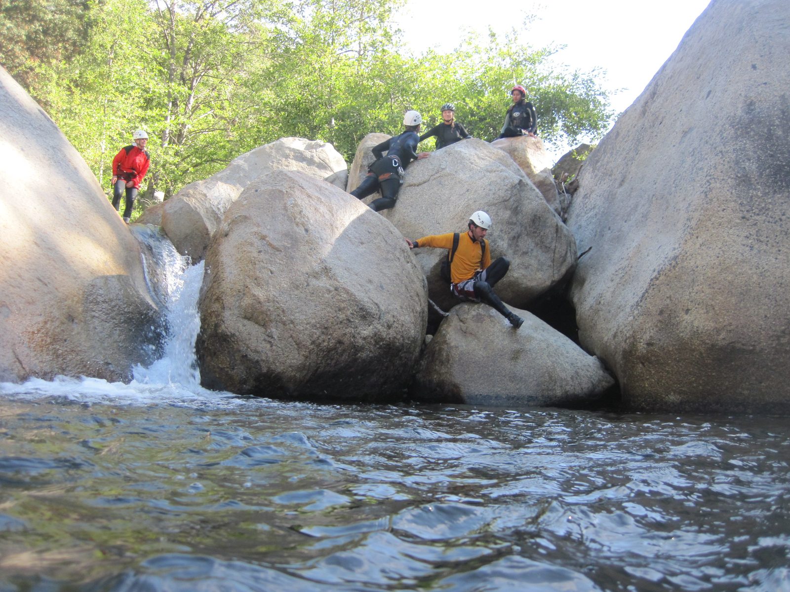 Jill, Colin, Julia, Aditi, and Eliah working a small bouldering problem.