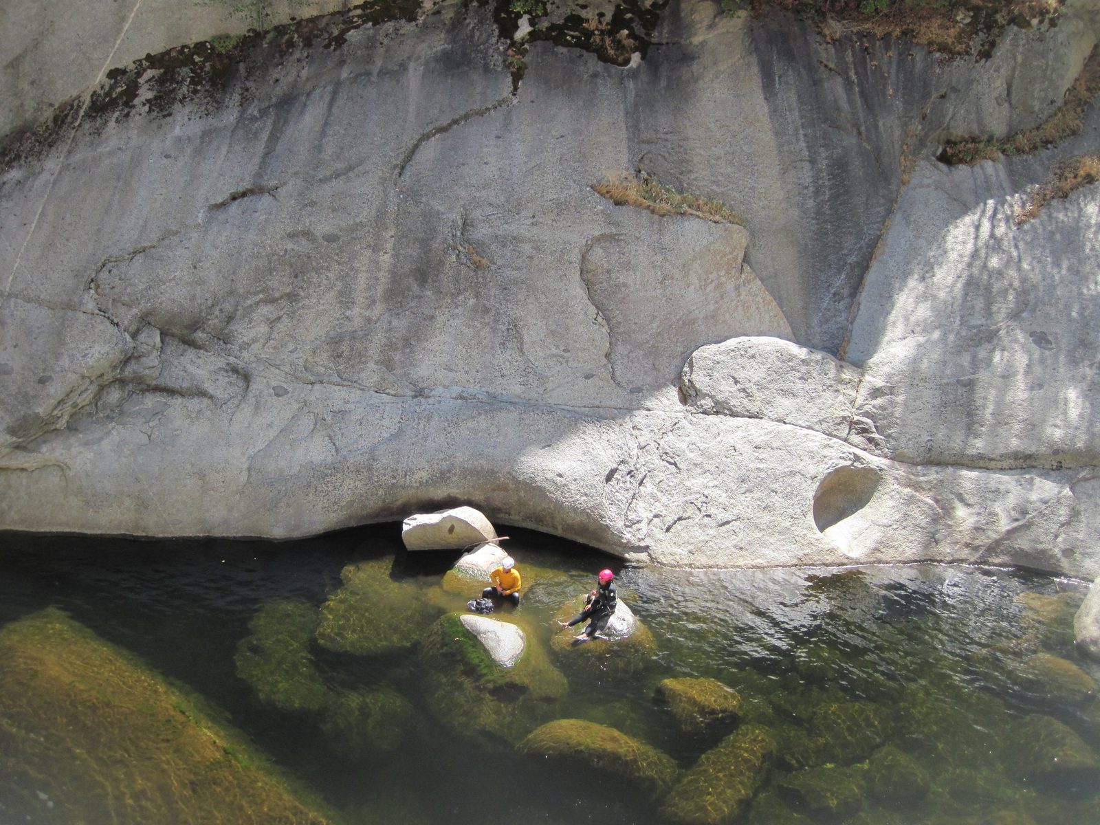 Aditi and Eliah find a rock to warm up on while the rest of the group descends.