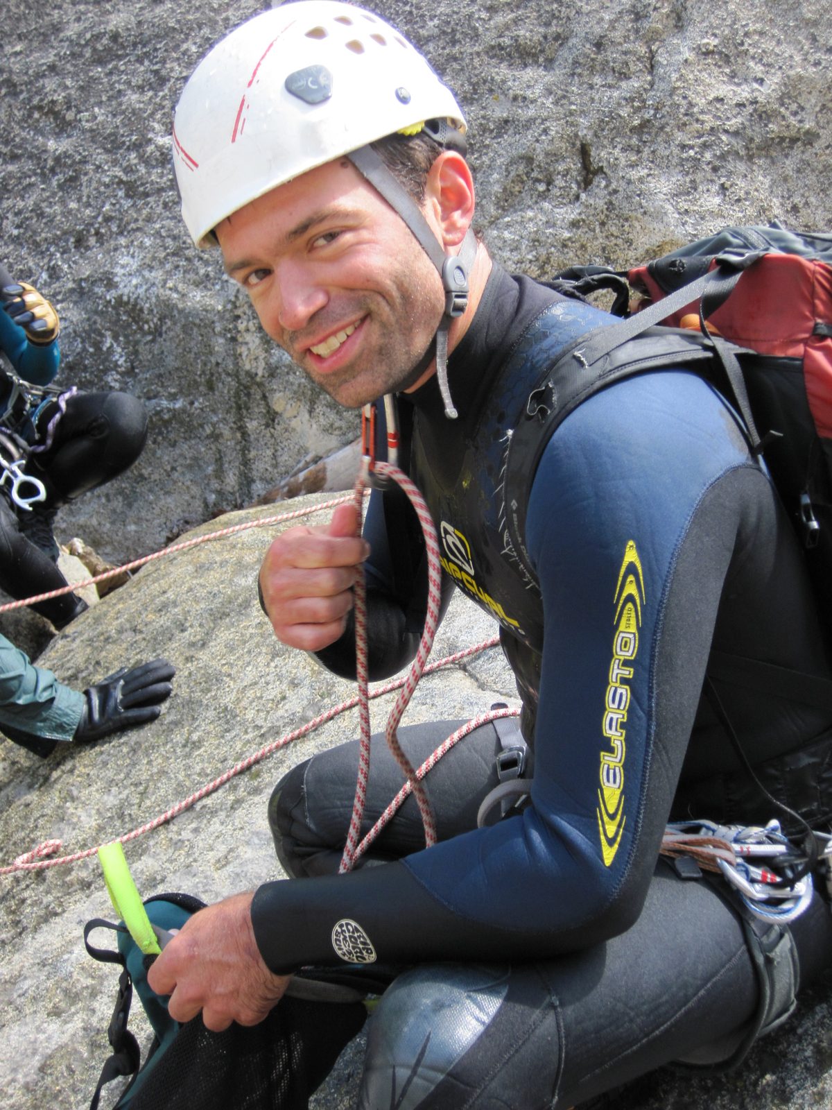 Colin, stacking extra rope in the rope silo through a carabiner on his neck strap. This is a...