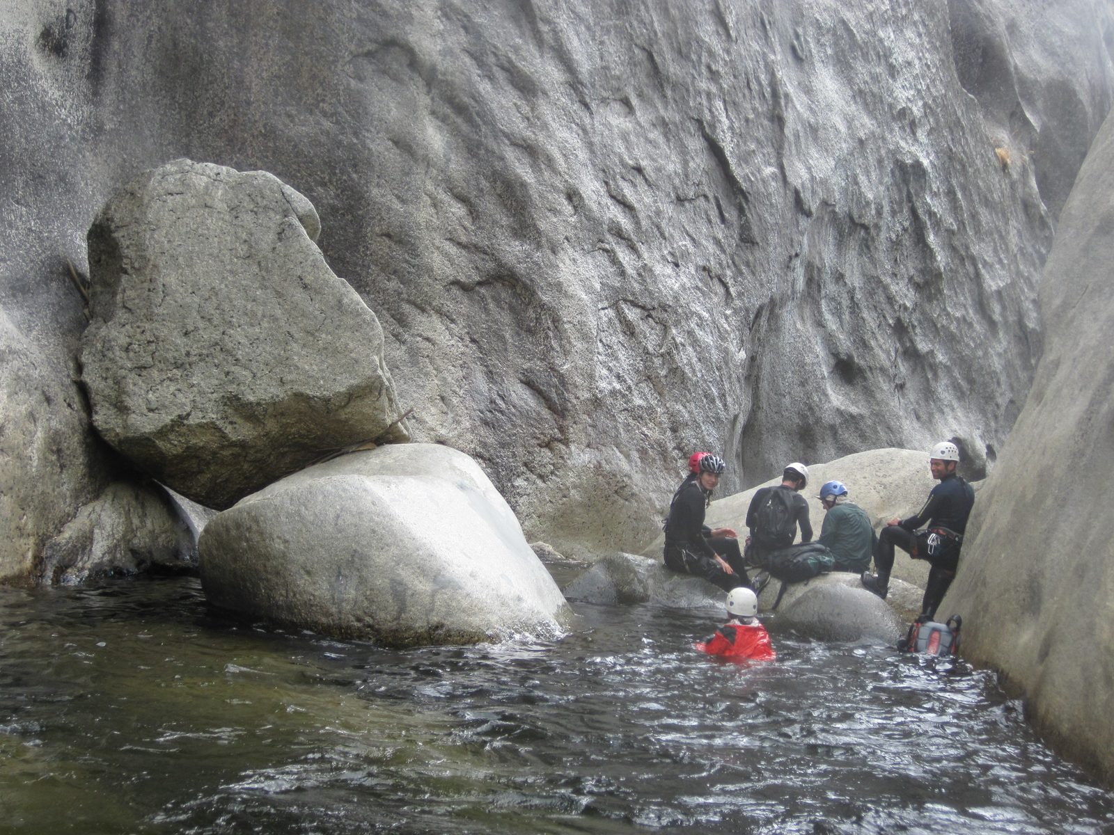 The crowd waits at the top of the next big rappel - through a hole into a cave in a waterfall.