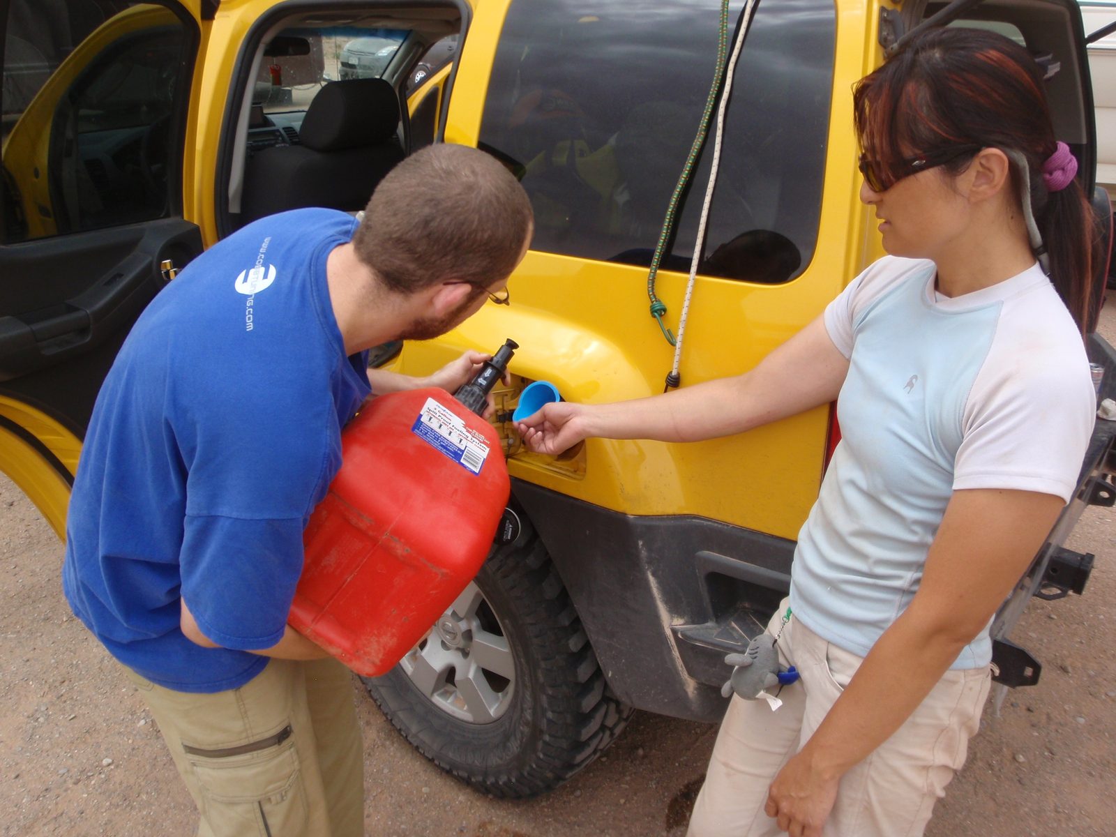 Joel trying to pour the extra fuel he bought into his tank.