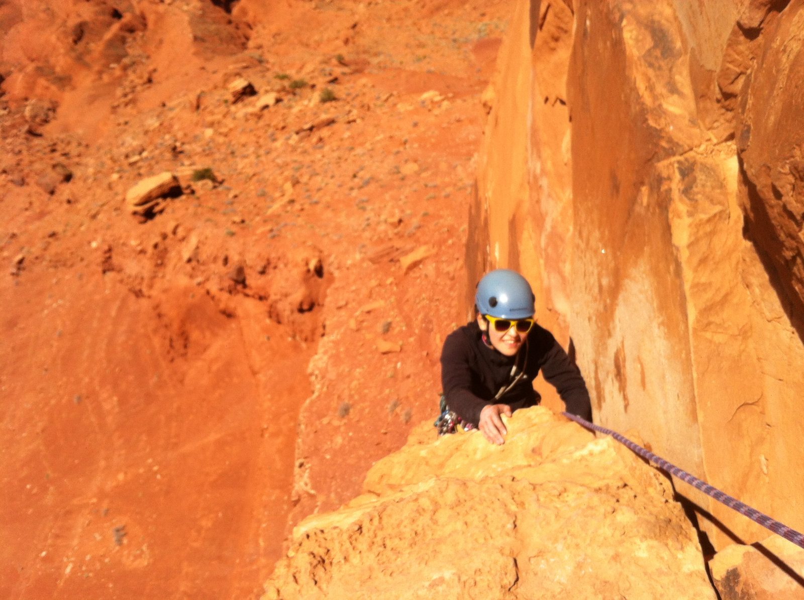 Monica, having passed the crux 5.10+ traverse on Pitch 3, rounds the roof and climbs some fun...