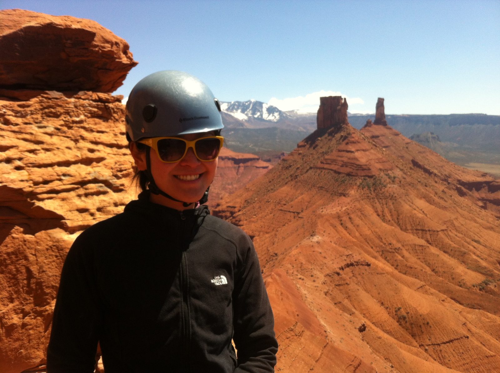 Monica at the top of the 4th pitch of Jah Man, with Castleton and the snow-capped Lasals in the...