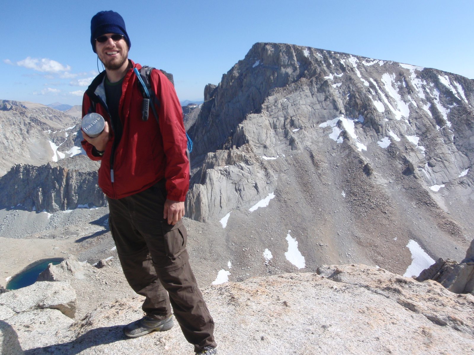 Joel, on the west summit of Russell, with the summit register can in his hand and the northern...