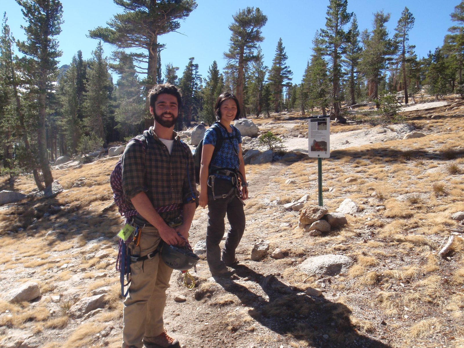 Alex and Monica standing by a sign that says that a large area of the mountain is under...