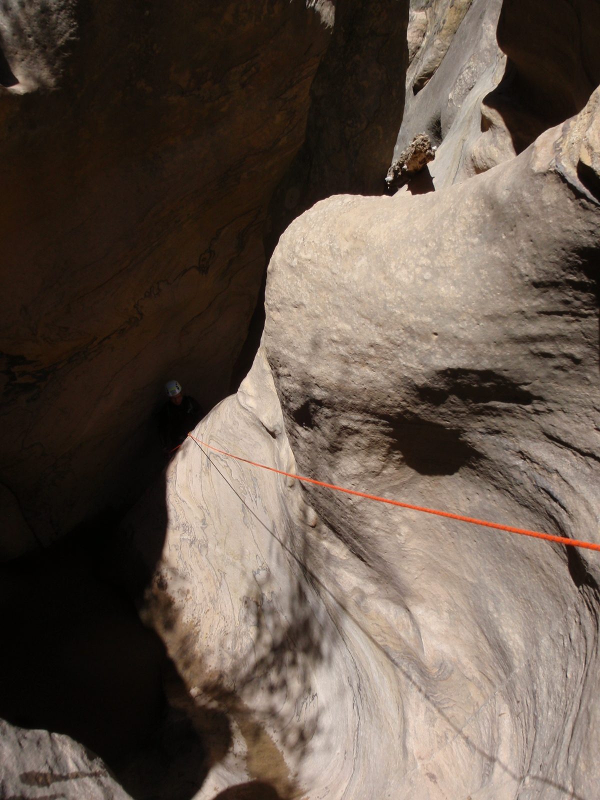 Andy disappearing around a corner on rappel in Pine Creek Canyon