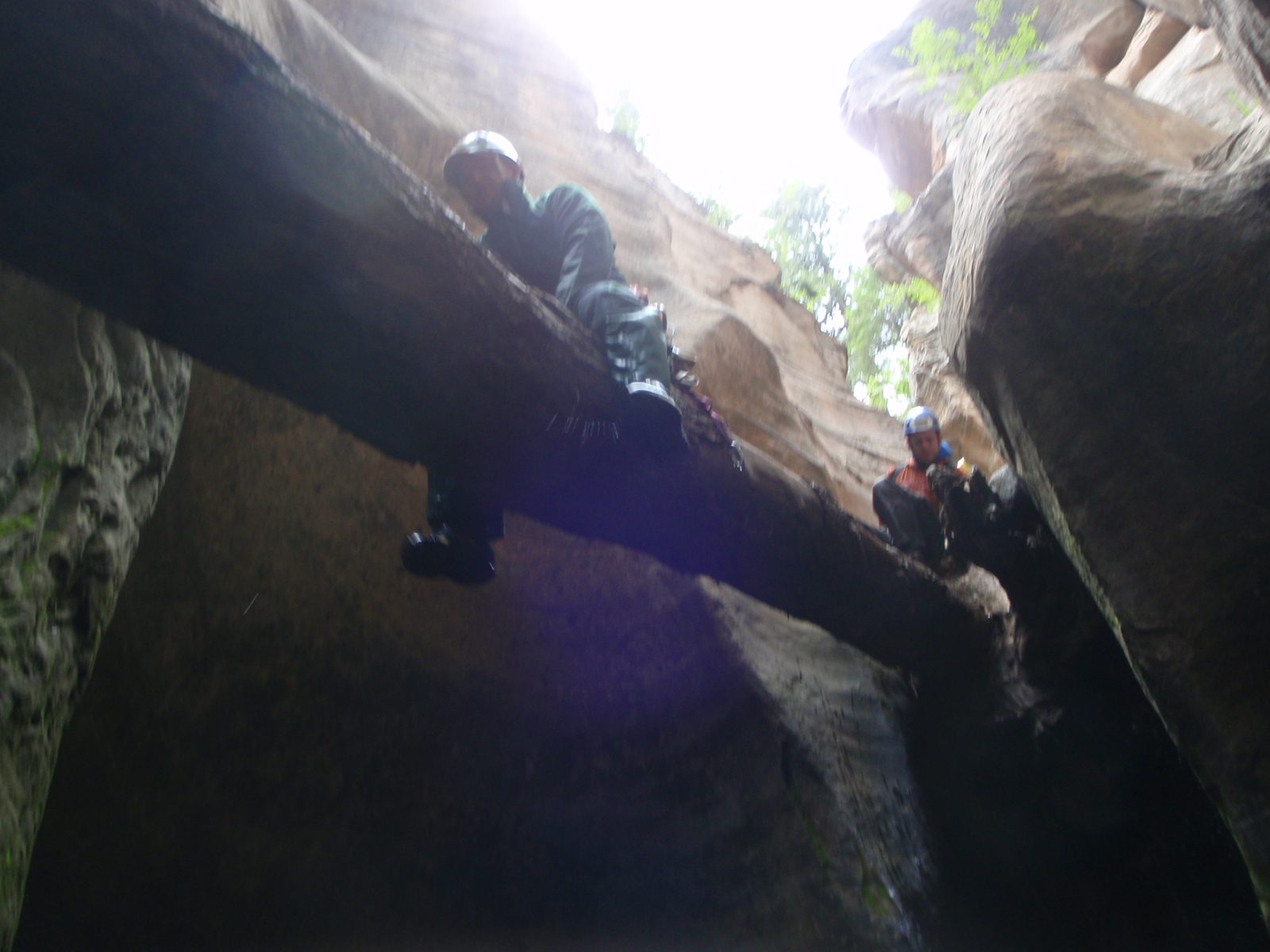 Mike shimmies down a log to avoid a rappel and pass over a large pool.  Joel waits in the background.