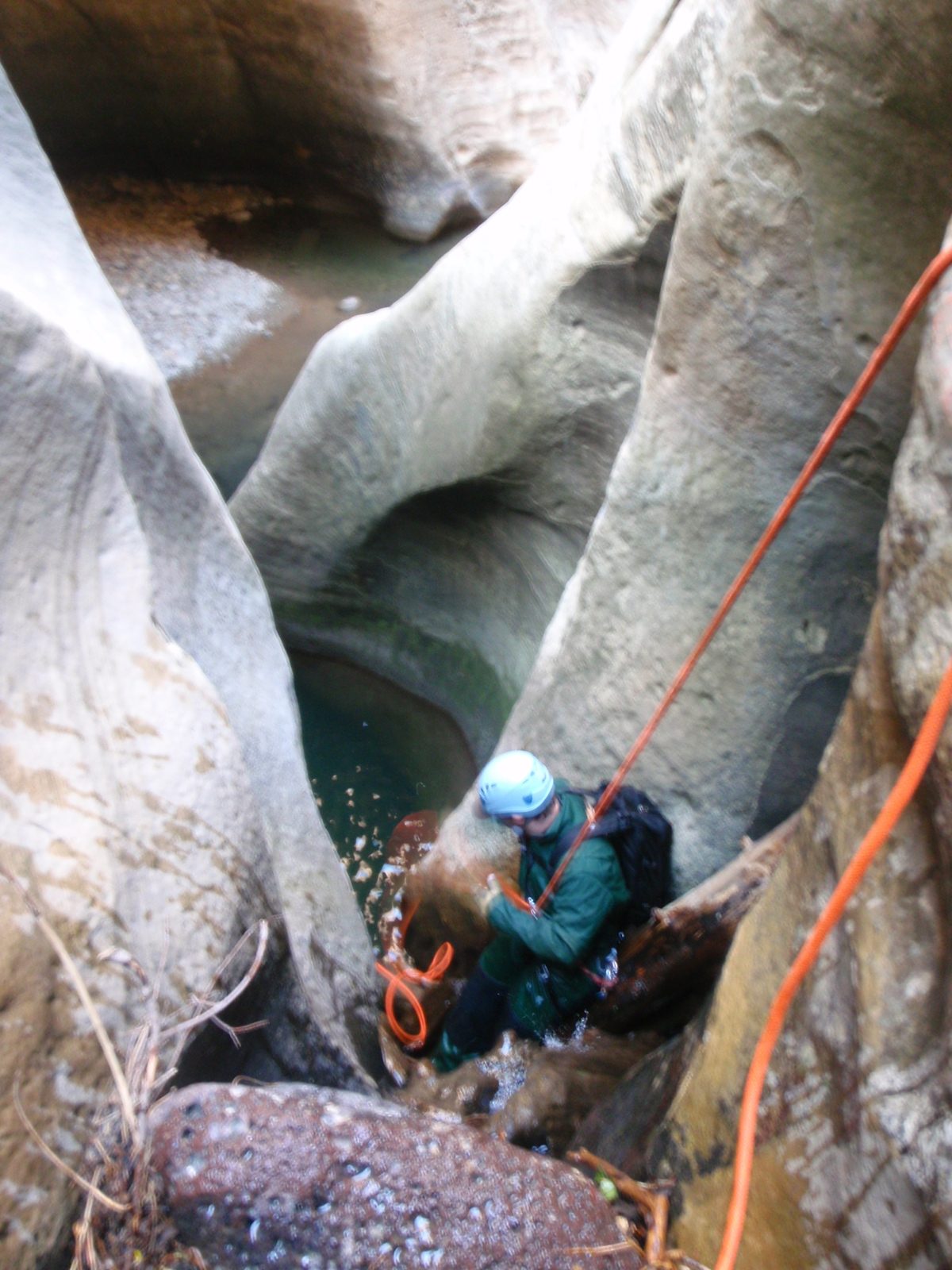 Mike, maneuvering past some logs and debris while on one of the final rappels in Kolob Canyon.