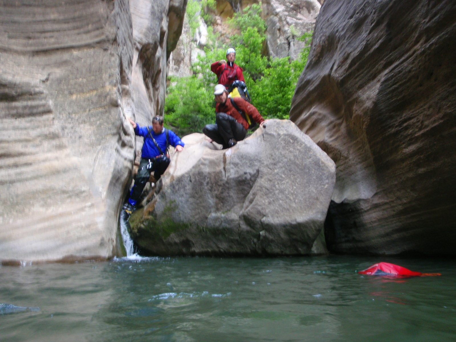 Mike downclimbs a small waterfall into a nice cold morning swimming pool, while Joel crouches...