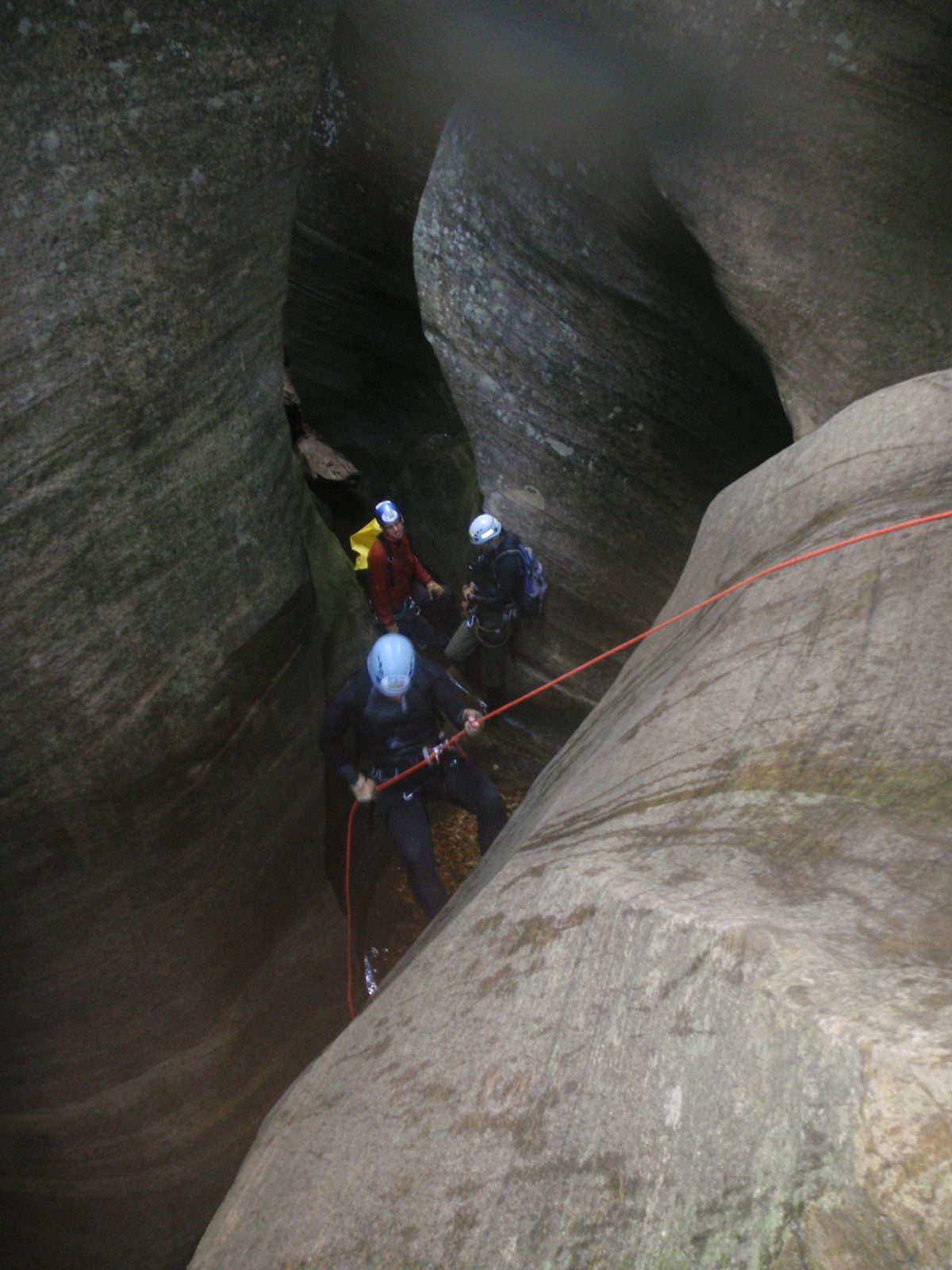 Mike rappels while Joel watches and Andy plays with his camera.  I think Monica is giving a...