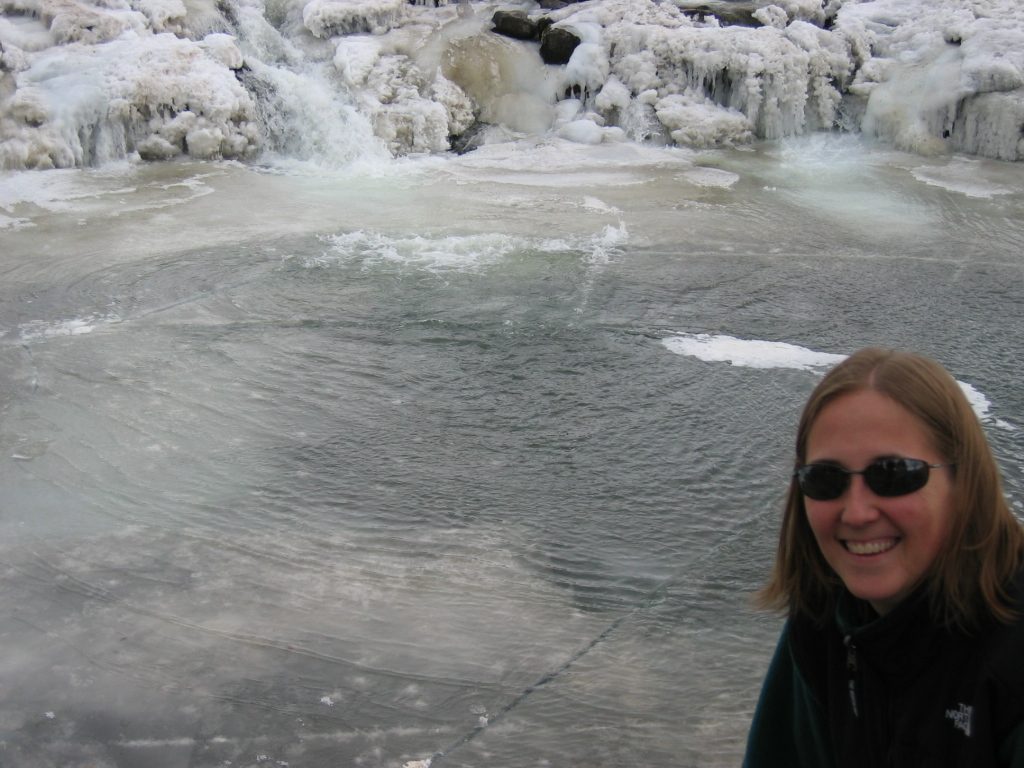 Catherine over the cracks in the ice at the base of the falls.  Slipping would be a bad idea...