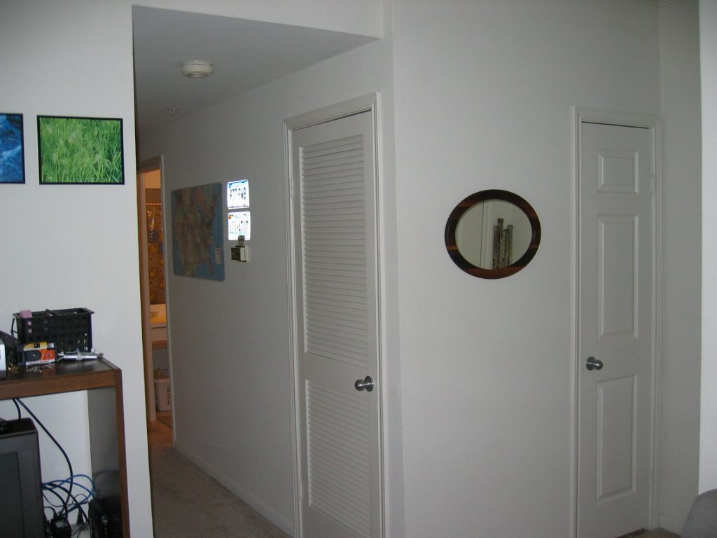 Looking down the hall towards bedroom with portion of entertainment center visible
