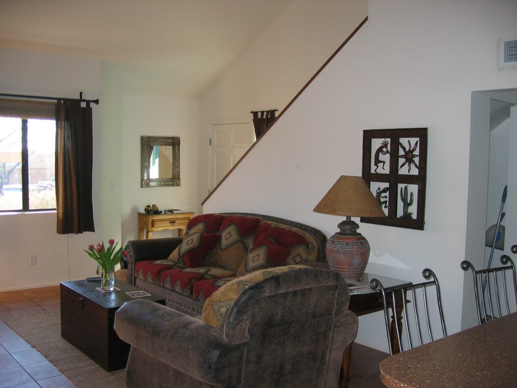 Living area ... front door is in center of picture ... stools are at the kitchen counter