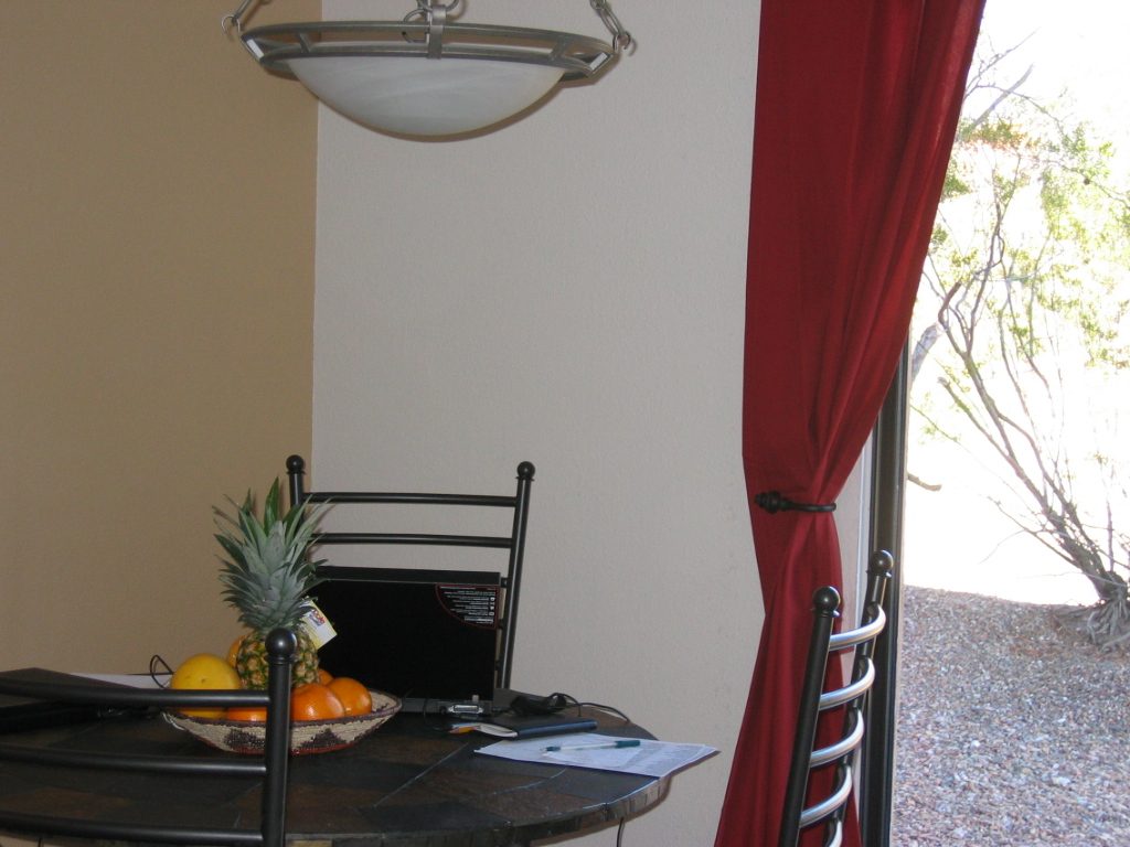 Dad's office set up at the dining room table which has been graced by a pineapple and some fruit...