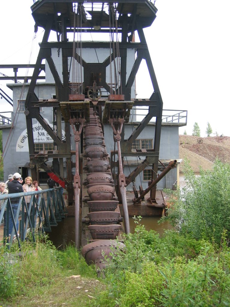 This is a dredge.  The buckets go down in the stream, scrape against bedrock and pick up buckets...