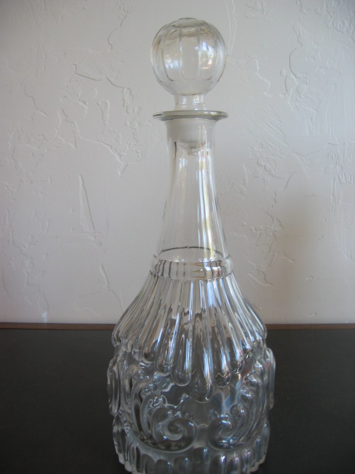 Decanter with ribbed ball top and decorative body; maybe an antique.  Probably reproduction