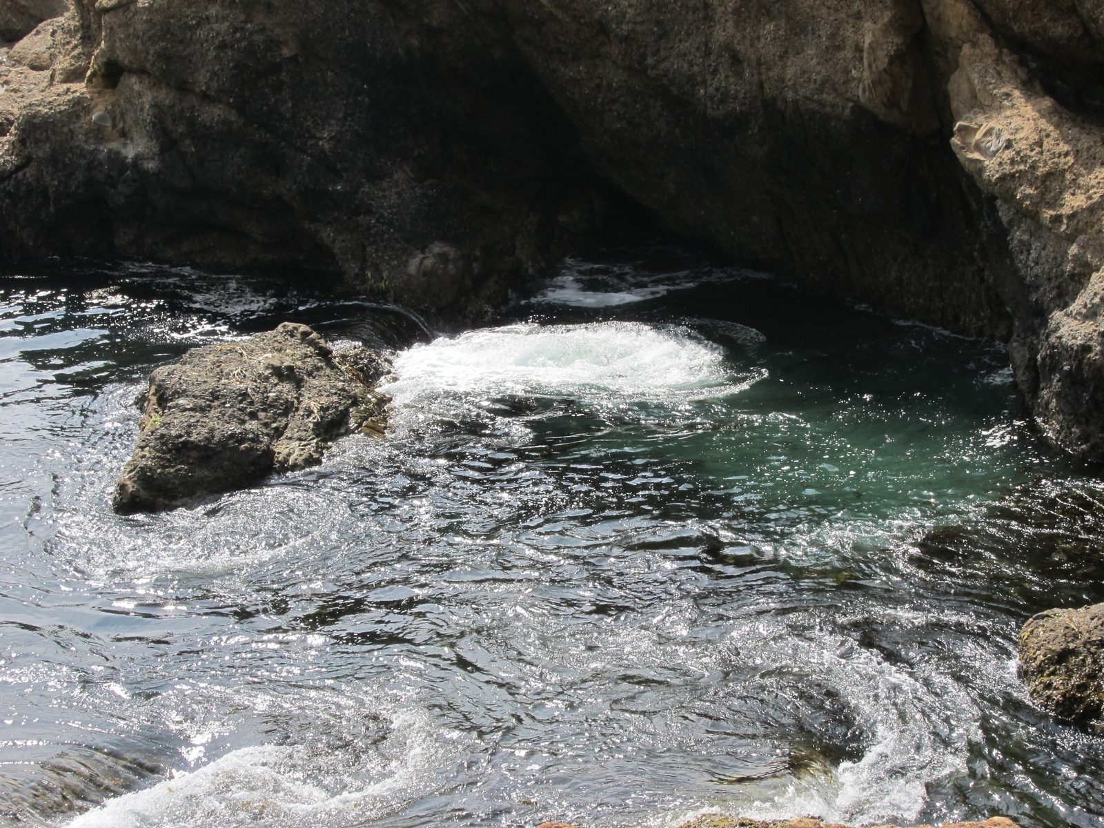 It's wierd water action.  The wave crests over the rock on the left, and some how a...