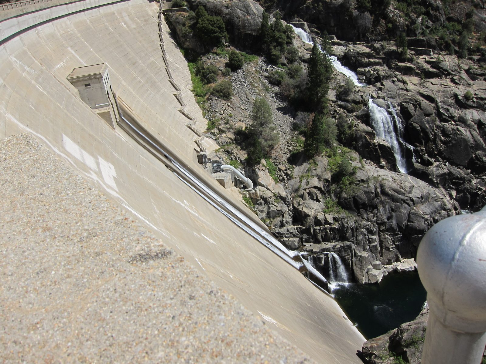 The south face of the dam, with the mild overflow trickling down to the river.