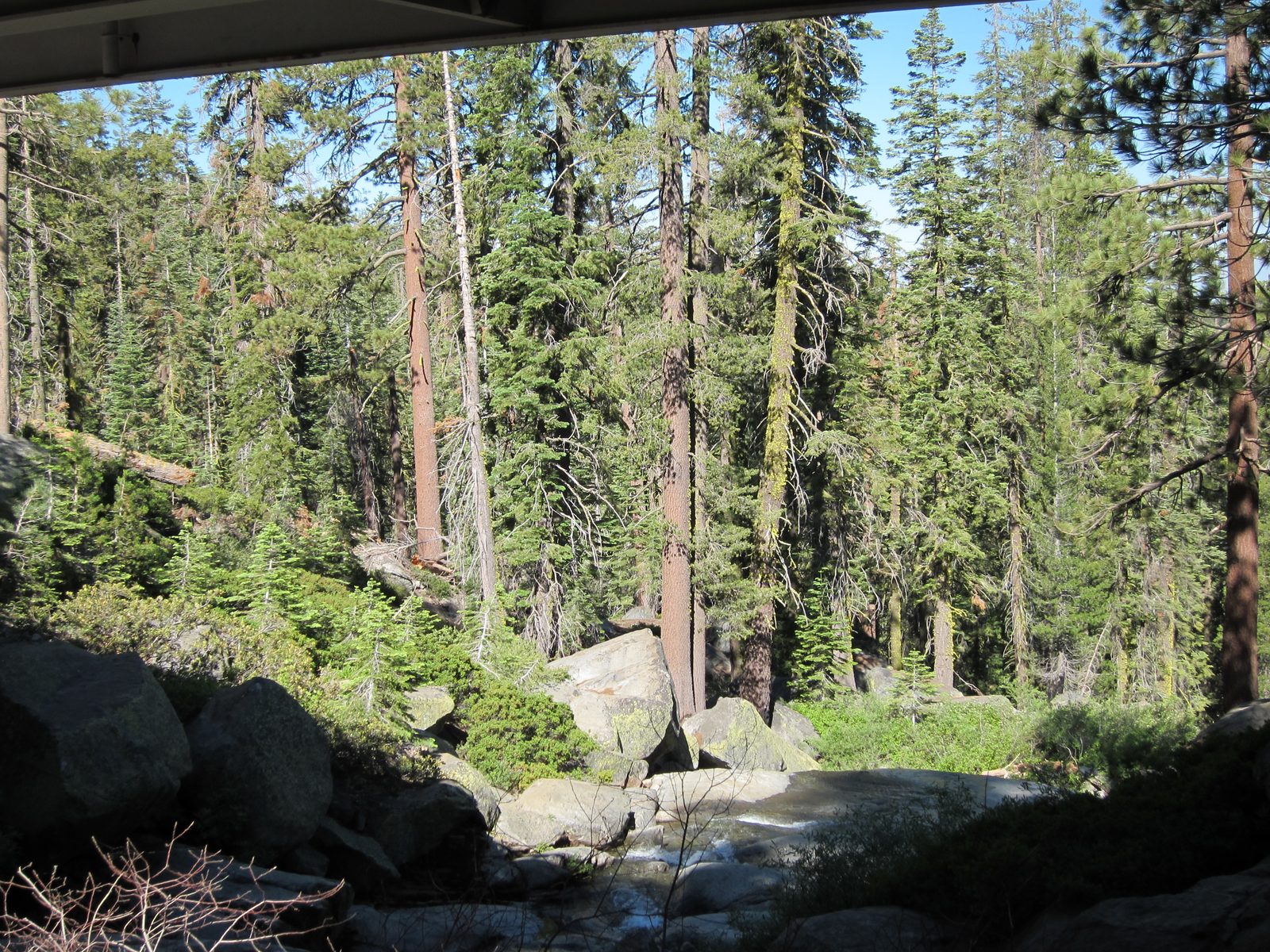 The waterfall fed a creek which coursed under the highway bridge.
