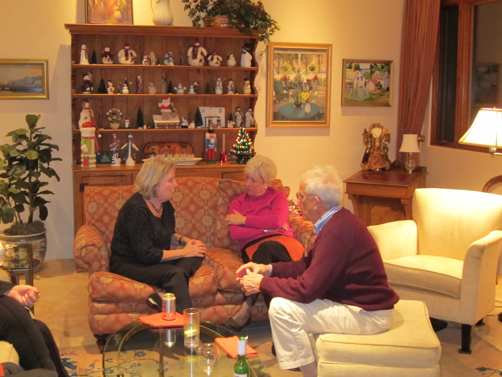 Judy Brown talkng to Taffy Eiff on the couch, with Jim Brown looking on