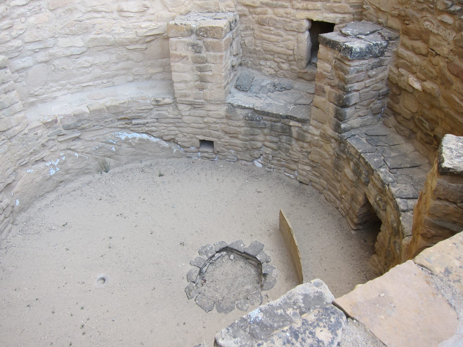 One last look into a kiva, which has a fire pit (large stone-surrounded circle, a deflector (the...