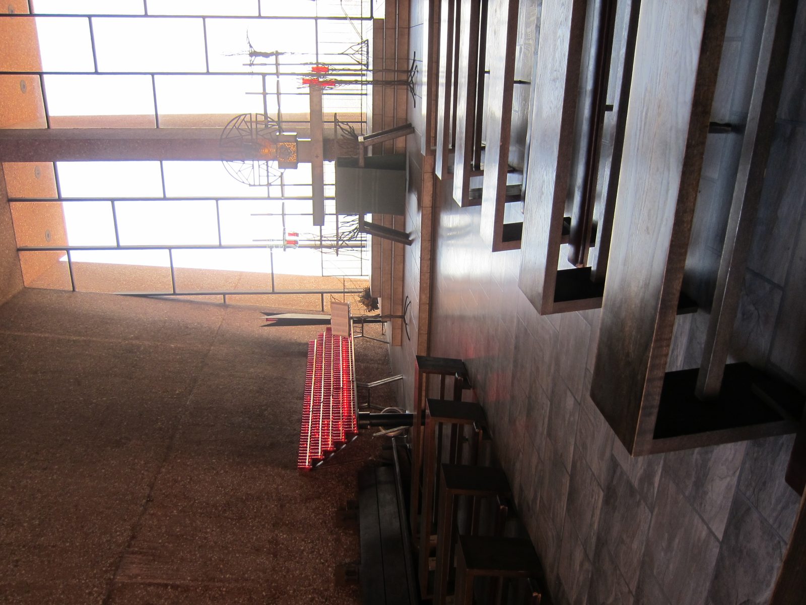 Inside the church.  Hard to pick out, but the pew side supports are not vertical; they bend in.
