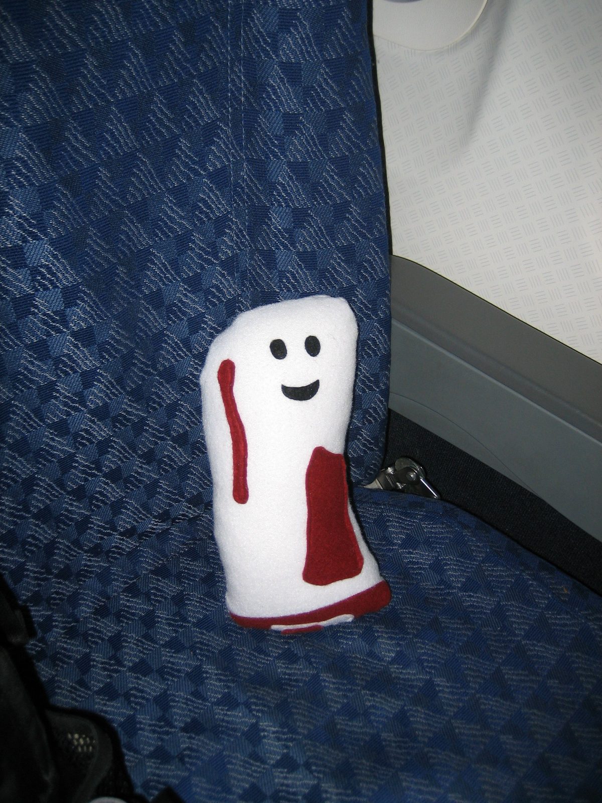 Bacon-y sits in his (quite spacious) coach seat on his way to Dallas.