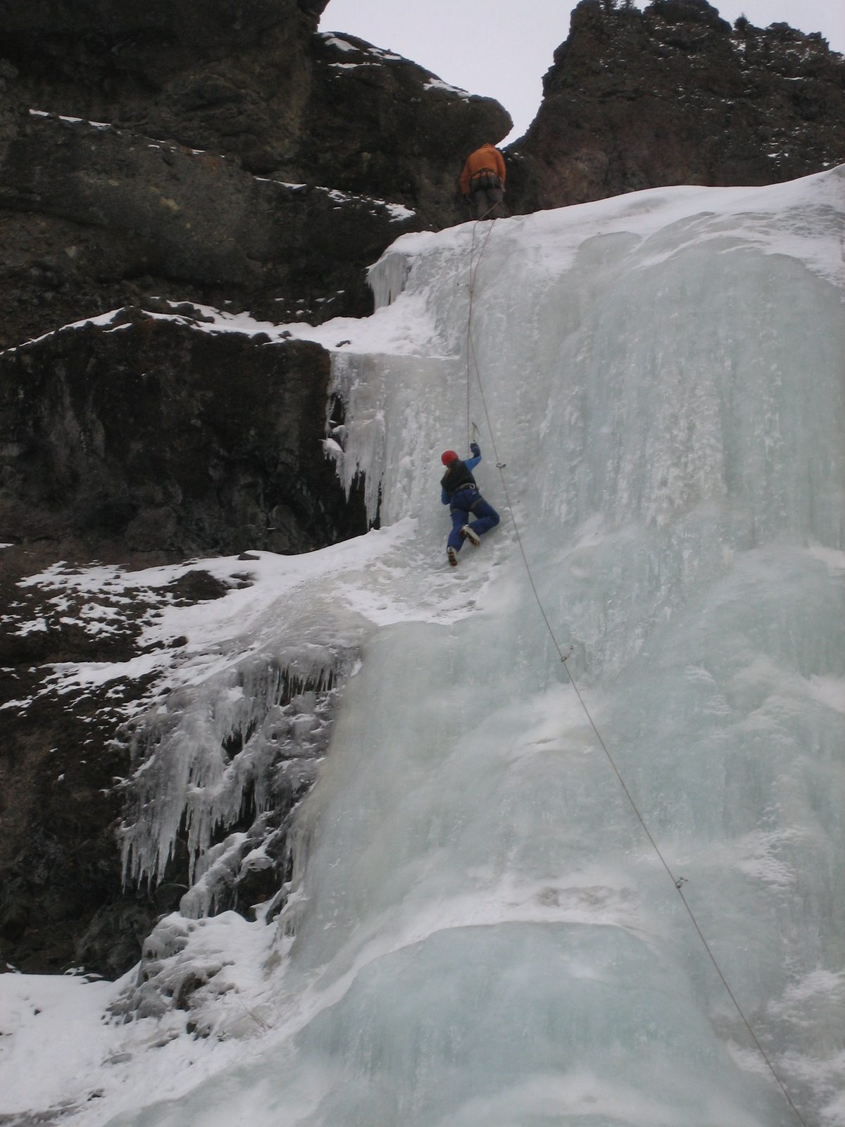 Catherine nears the top of the wall; Joe belays from above.