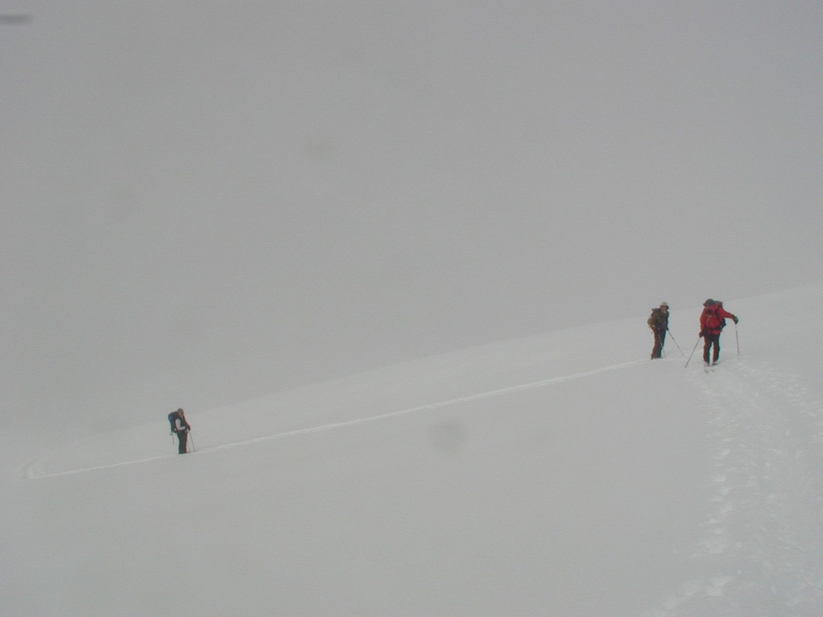 From left to right, John R., Al and Cathy waiting for Bob to cross an avalanche-prone slope.